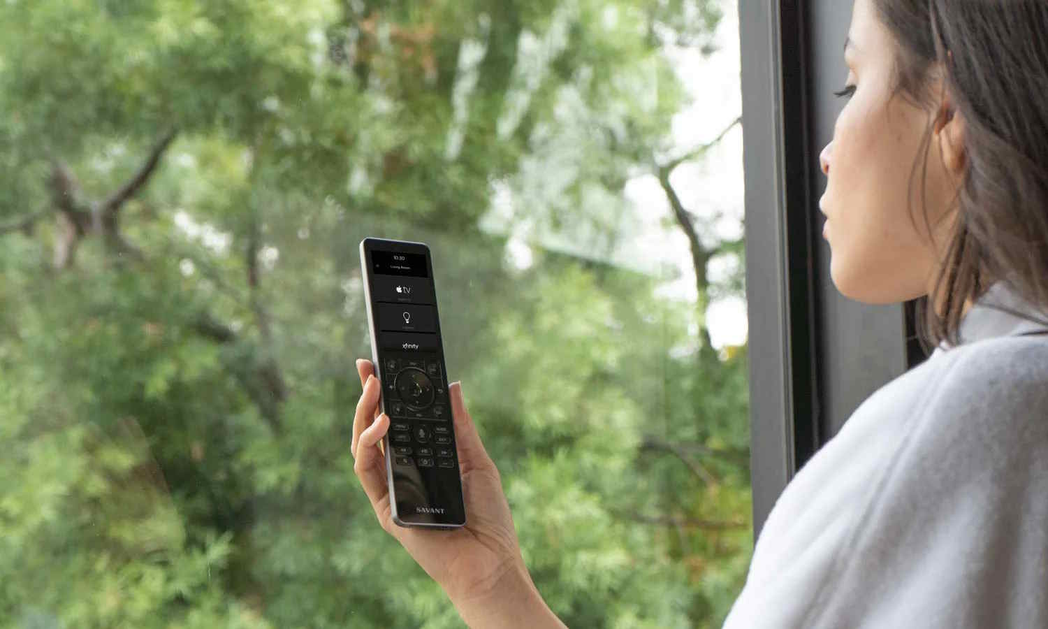 Four people sitting on a couch in a cozy, dimly lit home theater, watching a movie on a large screen with warm ambient lighting.